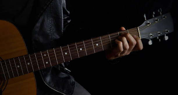 istock musician with a guitar on a black background in a leather jacket 1285478046