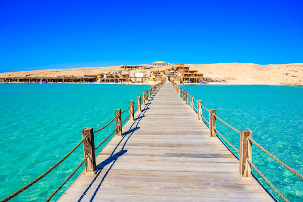 wooden pier am orange bay beach mit kristallklarem azurblauem wasser und weißem strand - paradiesische küste der insel giftun, mahmya, hurghada, rotes meer, ägypten. - hurghada stock-fotos und bilder