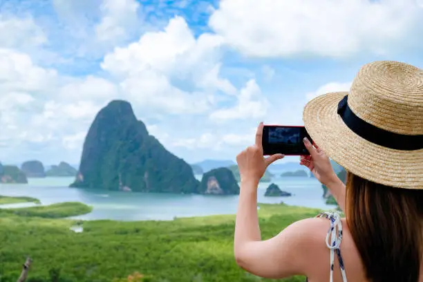 Photo of Happy Young Traveler Woman Raised Arm take a photo To Sky Enjoying A Beautiful Of Nature