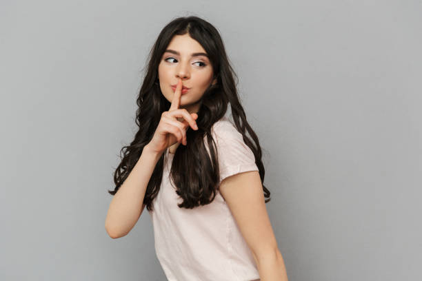 istock Beautiful young lady standing isolated showing silence gesture. 1285484236