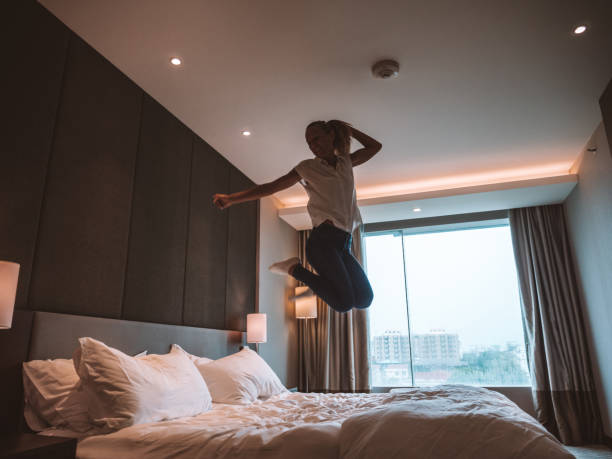istock Woman jumping on bed in room 1285484531