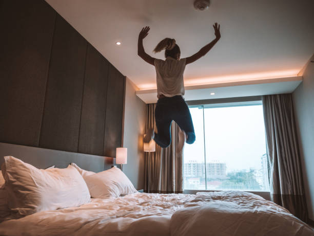 istock Woman jumping on bed in room 1285484633