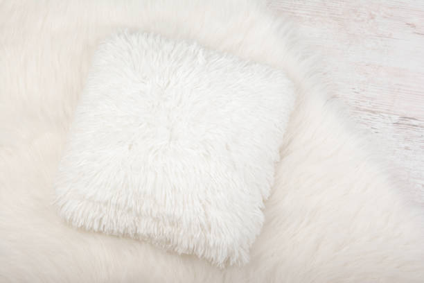White shaggy carpet and cozy pillow background. Home interior background White shaggy carpet and cozy pillow background. Home interior background. shaggy fur stock pictures, royalty-free photos & images