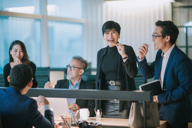 group of asian chinese white collar worker having a break during work late and taking snack at the workstation office place of work bonding