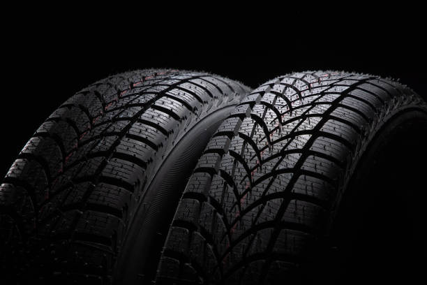 istock Winter Car tire on black background 1285487760