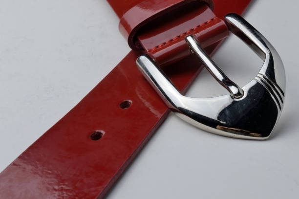 istock red women's belt with a chrome plaque on a white background. close-up. 1285488083