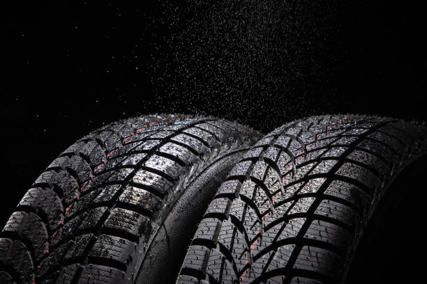 istock Winter Car tire and rain drops on black background 1285488193