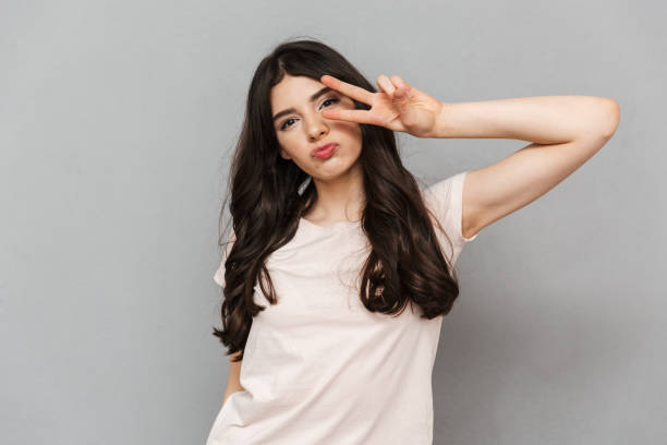 istock Pretty cute young lady showing peace gesture. 1285489070