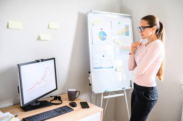 istock Woman stands in the office and looks at PC screen 1285491027