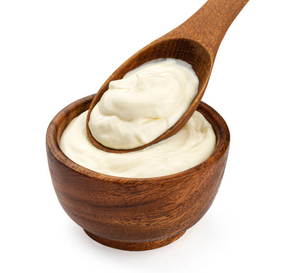 istock Sour cream in wooden spoon isolated on white background 1285492396
