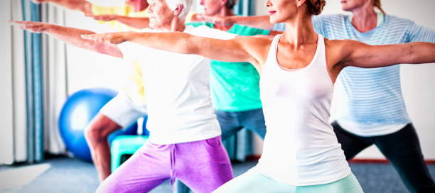 istock Instructor performing yoga with seniors 1285492430