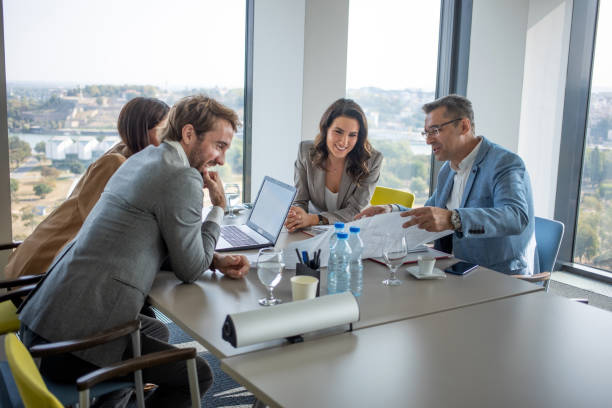 istock Cheerful colleagues looking at blueprints 1285493617