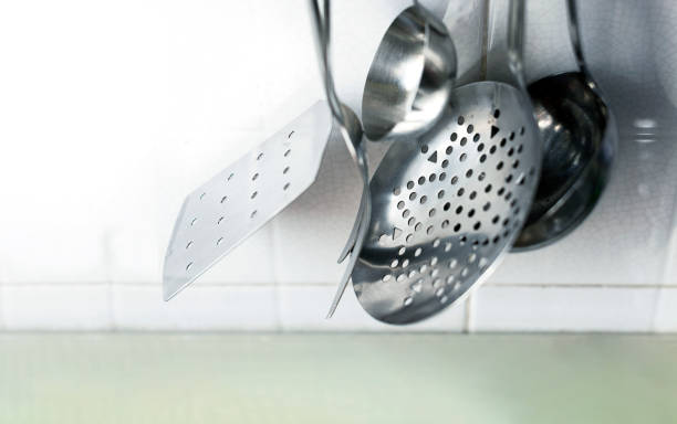 istock Metal kitchen utensils hanging on the tiled kitchen wall 1285495994