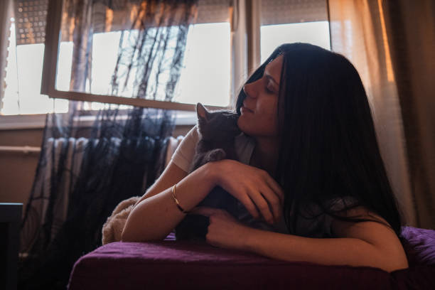 istock Young woman hugging her cat while cat is kissing her 1285498509