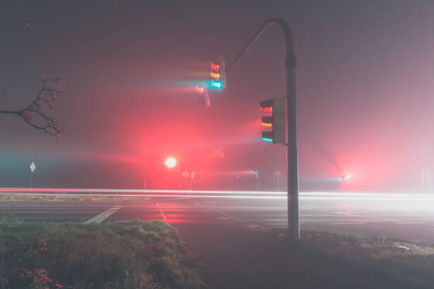 istock traffic lights in fog at night, side view 1285498796