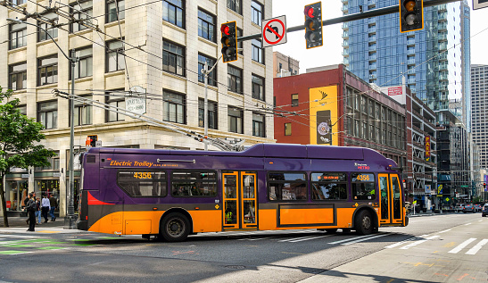 Seattle, Washington State, USA - June 2018: Zero emissions electric trolley bus turning a corner on a street in Seattle city centre.