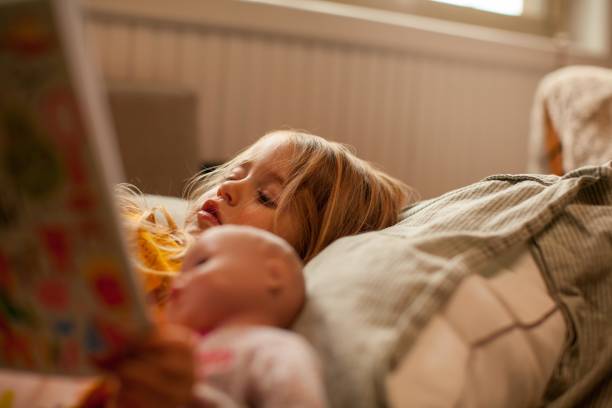 малыш девушка читает книгу - baby doll dress стоковые фото и изображения