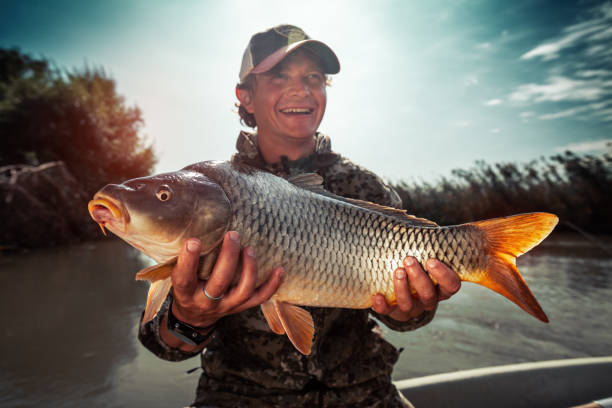 istock Happy young fisherman holds the big Carp fish 1285500034