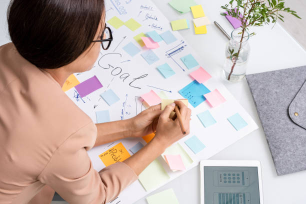 istock Young brunette businesswoman making notes on notepaper over large document 1285500467