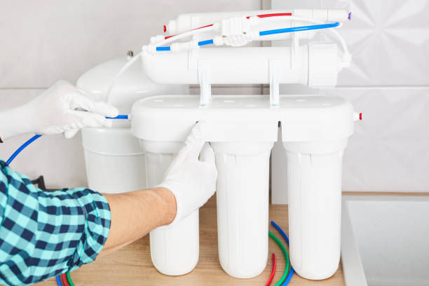 istock Installation purification osmosis system. Plumber or man hand replace water filter cartridges at home kitchen. 1285501271