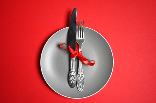istock Christmas table with a plate, fork, knife. top view, copy space. against a red background 1285501424