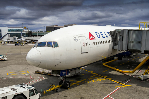 Seattle, Washington State, USA - June 2018: Delta Air Lines Boeing 777 jet attached to a passenger air bridge at Seattle Tacoma airport.