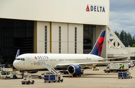 Seattle, Washington State, USA - June 2018: Delta Air Lines Boeing 767 jet parked outside a maintenance hangar at Seattle Tacoma airport.