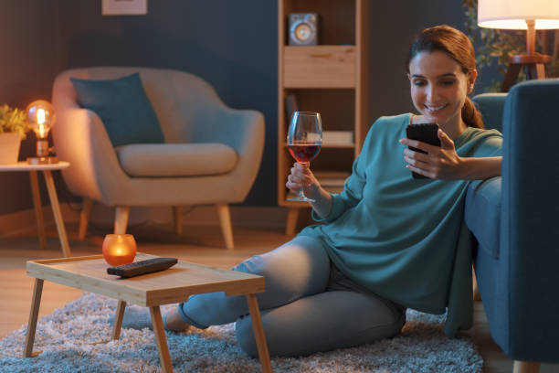 mujer tomando una copa de vino y conectándose en línea - glass drink alcohol red fotografías e imágenes de stock