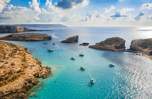 Aerial view of Comino island, Blue lagoon and boats, sky blue. Malta