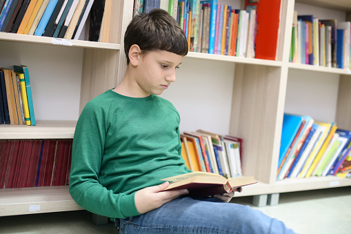 Boy in a school library. About 9-10 years old, Caucasian male.
