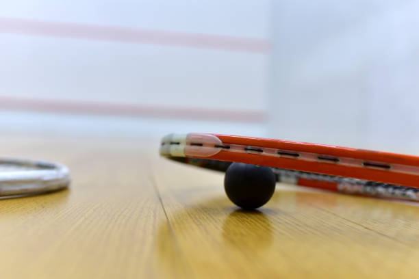 squash racket and ball on court floor in training club. sports equipment and sportswear for playing squash - slenderize imagens e fotografias de stock