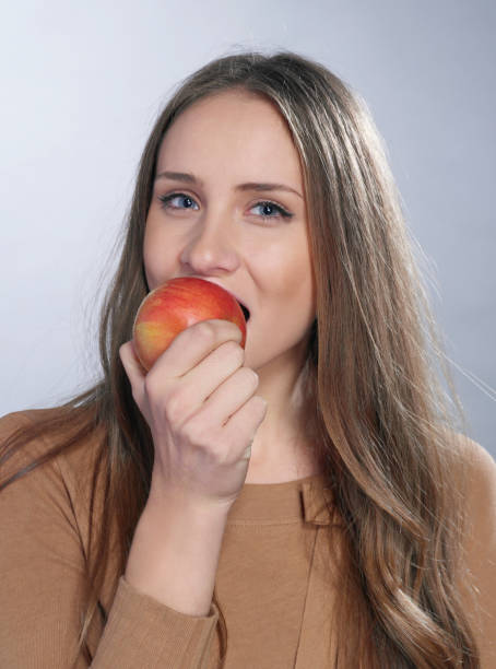 istock Cheerful girl with apple 1285508324