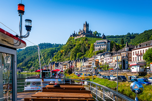 Cochem, Germany - August 07, 2020: Panoramic image of Cochem with old Reichsburg castle. View from a tourboat on Mosel River