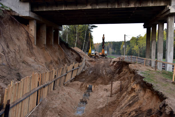 koparki z osprzętem wiertniczym na placu budowy podczas naprawy mostu. sprzęt do wiertarki skalnej i sonda wibroflotacji. - drill borehole mining rock zdjęcia i obrazy z banku zdjęć