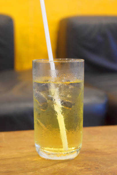 istock Honey lemon green tea with ice in glass with black drinking straw on table with blurred background 1285508504