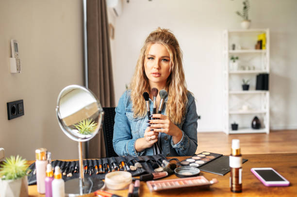 istock Young woman looks at mirror and doing makeup 1285509694