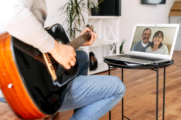 istock Guy plays guitar to parents via video call 1285511763