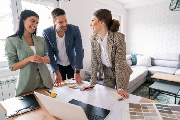 istock Female designer and a young couple talking about renovation plans 1285513016