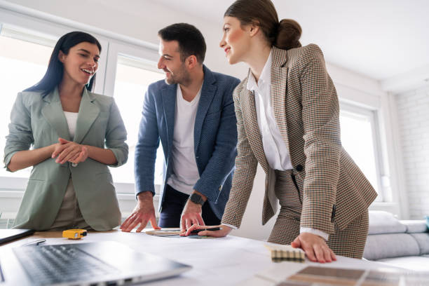 istock Couple and a female designer talking about renovation plans 1285513023