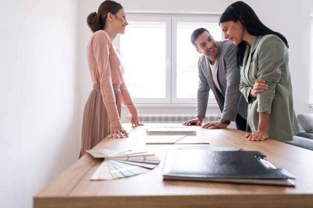 istock Happy couple making remodeling decisions with a young interior designer 1285513037