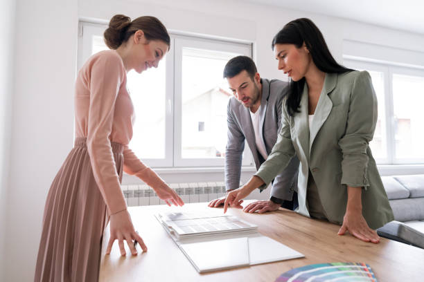 istock Young couple making decisions about remodeling an apartment with a young designer 1285513044