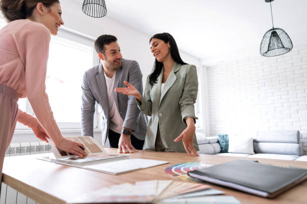 istock Young couple making remodeling decisions with a young interior designer 1285513046