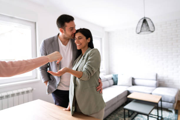 istock Smiling couple receiving new apartment keys 1285513082