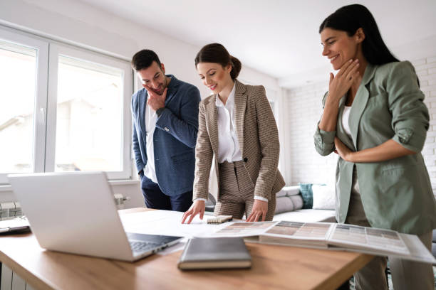 istock Young female architect showing young couple her renovation plans 1285513097