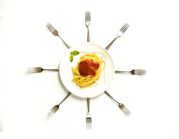 italy. spaghetti on the plate with the forks forming the hands of a clock