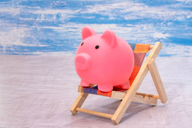 istock Pink piggy bank sat in a deckchair 1285513366