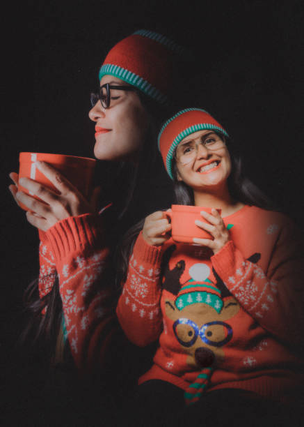 Christmas Ugly Sweater Retro Portrait A Filipino adult women celebrates the holiday taking a portrait wearing an "ugly" Christmas sweater and holding an oversized coffee mug.  Vintage styled portrait in 1980's style. christmas sweater photos stock pictures, royalty-free photos & images