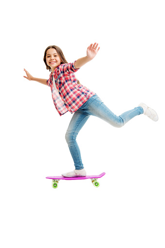Street and park skateboarding. Happy child ride penny board. Little girl perform skateboarding tricks. Enjoy skateboarding. Action sport and activity. Transportation. Skateboarding is good workout.