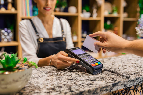 istock Hand of customer paying with contactless credit card with NFC technology. 1285517098