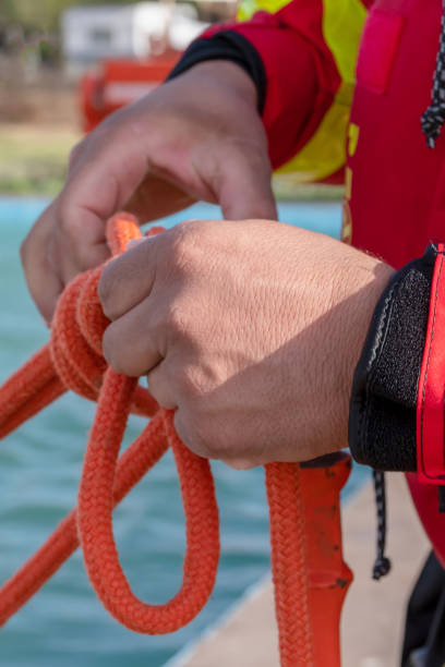 istock firefighter hands tying rope knot, vertical photo. 1285518168